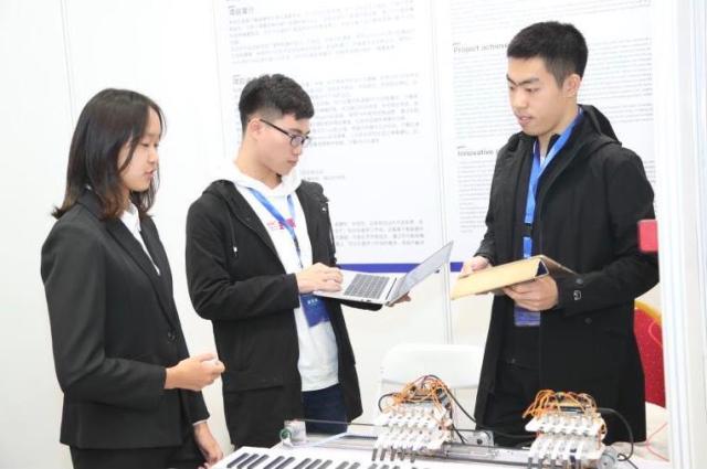 北航hjc黄金城学生韩腾飞,带来其团队研发的会弹钢琴的机械手。(中关村管委会供图)